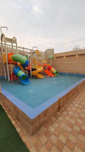a pool with a water park with a water slide at شاليهات العاب مائية للأطفال بالدرب in Qarār