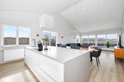 una cucina e una sala da pranzo con pareti e finestre bianche di Luxury Villa in Golden Circle with hot tub a Selfoss
