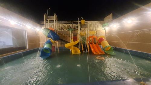 een zwembad met een waterpark met een glijbaan bij شاليهات العاب مائية للأطفال بالدرب in Qarār