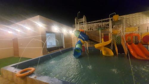 a water park with a swimming pool with a water slide at شاليهات العاب مائية للأطفال بالدرب in Qarār