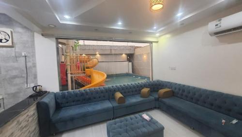 sala de estar con sofá azul y parque infantil en شاليهات العاب مائية للأطفال بالدرب en Qarār