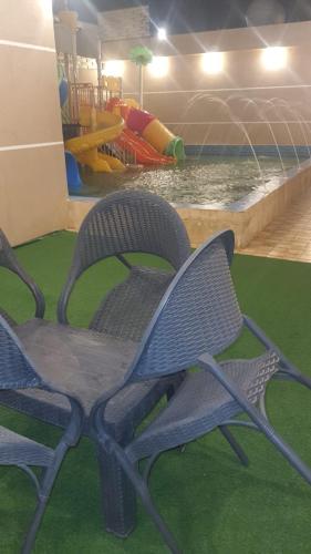 2 chaises en face d'un parc aquatique dans l'établissement شاليهات العاب مائية للأطفال بالدرب, à Qarār