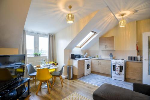 a kitchen and living room with a table and chairs at 1 bed Flat ''Charlie'' in Dewsbury Rd Leeds in Hunslet