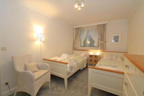 a small bedroom with two beds and a chair at Appartement-Freesensuen in Munkmarsch