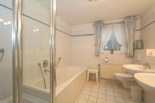 uma casa de banho com uma banheira, um WC e um lavatório. em Appartement-Freesensuen em Munkmarsch