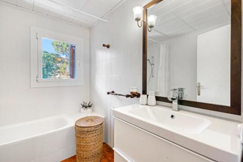 a white bathroom with a sink and a mirror at Casa Roure-4BR-Piscina-BBQ-Vistas Mar-Ping-Pong in Sant Cebrià de Vallalta