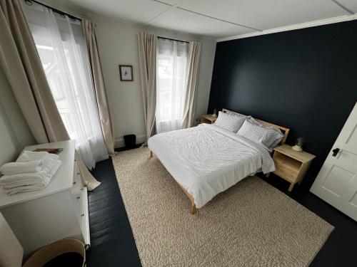 1 dormitorio con cama blanca y pared negra en Charming & Newly Renovated 2BR in St Albans, en Saint Albans