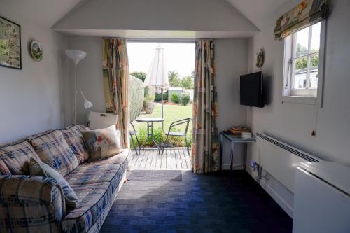 a living room with a couch and a window at Villa Shakespeare in Cambridge