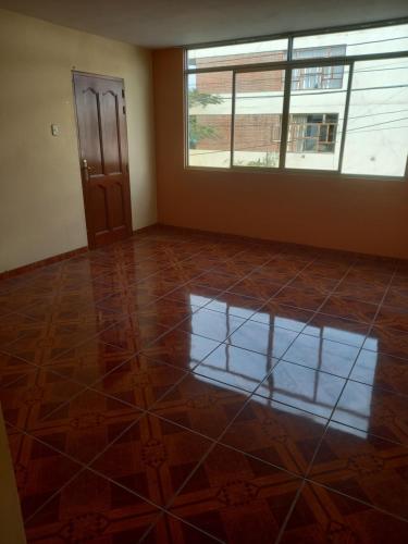 an empty room with a large window and a tiled floor at Alquiler de minidepartamento in Lima