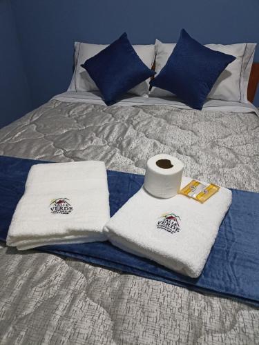1 cama con 2 toallas y un rollo de papel higiénico en HOSPEDAJE VALLE VERDE, en Oxapampa