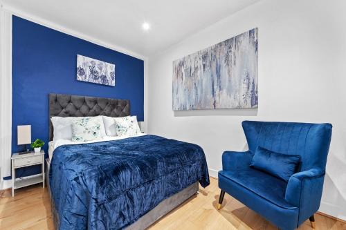 um quarto com uma cama azul e uma cadeira azul em Kensington Station Proximity 2-Bedroom Apartment, Walk to Station in 2 Minutes em Londres