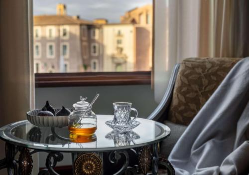 a glass table with a drink and a bowl of food at Anantara Palazzo Naiadi Rome Hotel - A Leading Hotel of the World in Rome
