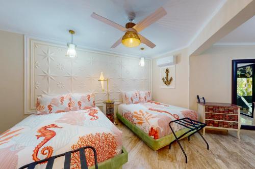 een slaapkamer met 2 bedden en een plafondventilator bij Villas Tropical 11 in Cancun