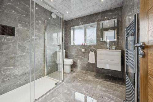 a bathroom with a shower and a toilet and a sink at house in Heald Green village in Manchester
