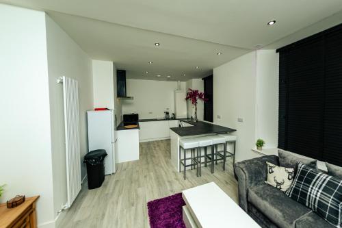 a living room with a couch and a kitchen at CHEERZ Apartments in Aberdeen