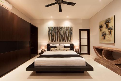 a bedroom with a bed and a ceiling fan at Amalika Private Pool Villa Central to Everything in Gili Trawangan