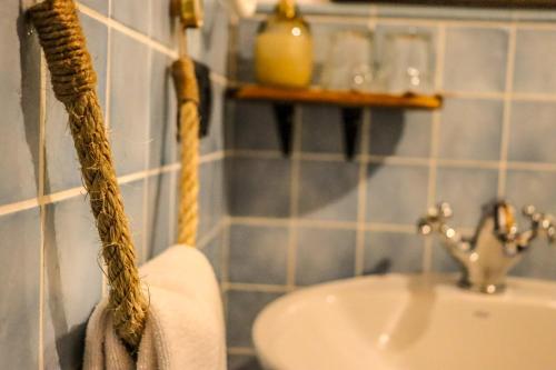 a bathroom with a sink and a towel hanging on the wall at Fogar de Lecer in Arzúa