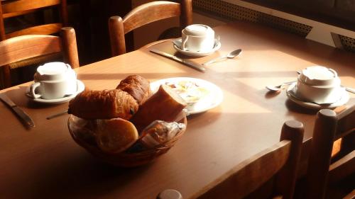 un tavolo con un cesto di pane e tazze sopra di Le Bel Air a Mions