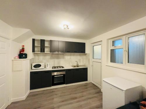 a kitchen with black and white appliances in a room at Kriss house in Bristol