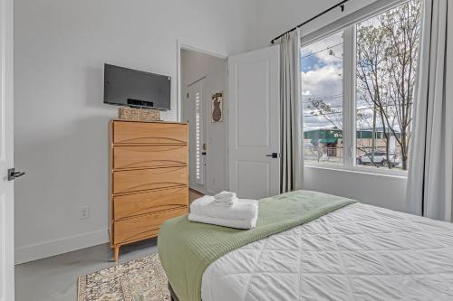 een slaapkamer met een bed en een dressoir met een flatscreen-tv bij Dixieland Delight @ Skyline in Nashville