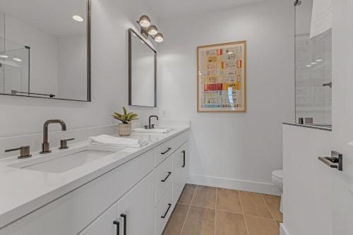 een witte badkamer met 2 wastafels en een spiegel bij Dixieland Delight @ Skyline in Nashville