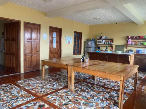 a kitchen with a wooden table in a room at El Jardín de Banu in Magdalena Milpas Altas