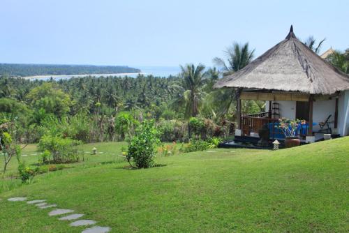 a gazebo on a hill with a green lawn at Villa The Jiwa in Tanjung
