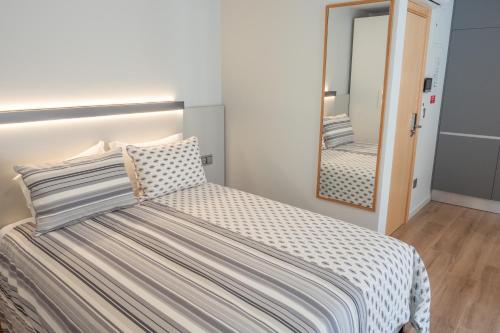 a bedroom with a bed and a mirror at RIACENTRUM - Smart Residence in Aveiro