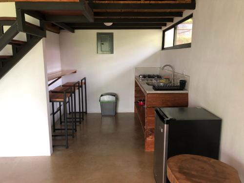 a kitchen with a counter and stools in a room at The Elements Costa Rica Nature Lodges in Platanillo