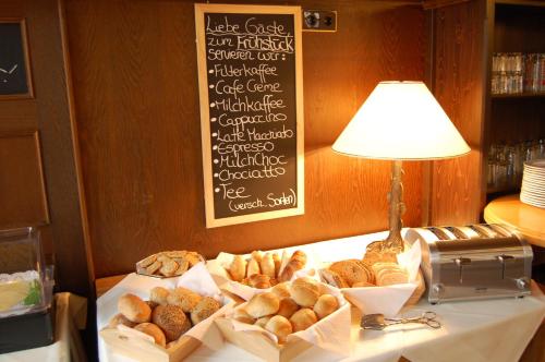a table topped with baskets of bread and a lamp at Stadthotel Detmold in Detmold