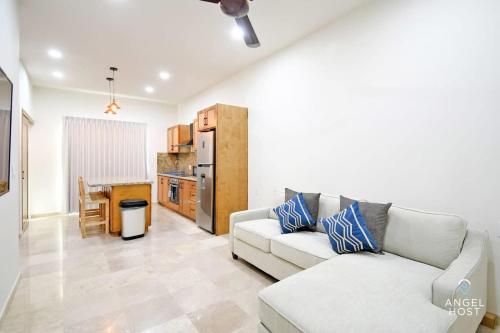 Una sala de estar con un sofá y una cocina. en NEW Condo with Pool and Ocean View Roof near Beach 4 blocks, en La Paz