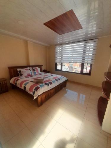 a bedroom with a bed and a large window at HOTEL BS in Nemocón