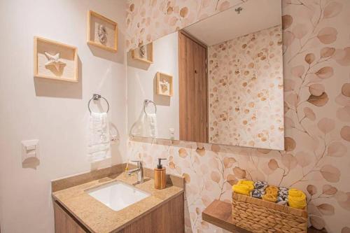 uma casa de banho com um lavatório e um espelho em Lujoso apartamento Rodadero sur con vista al mar em Gaira