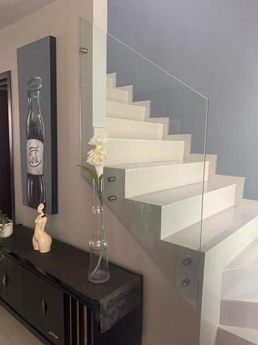 a vase with a flower on a dresser next to a staircase at Casa equipada cerca Andares, Auditorio Telmex y Estadio Akron in Guadalajara