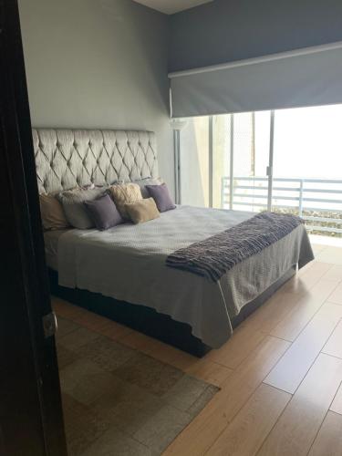 a bedroom with a bed and a large window at Excelente casa muy acogedora en condominio in Guadalajara