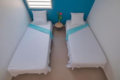 two twin beds in a room with a window at Villa Aléo in Sainte-Anne