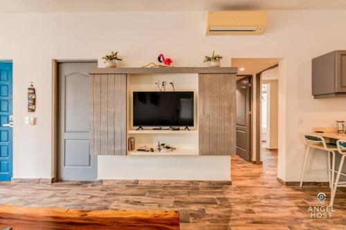 a living room with a tv on a wall at A Sublime Beach Getaway Perfect for a Family Gathering in El Cuyo