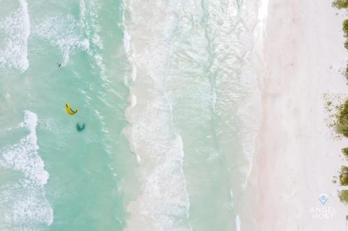 an overhead view of two people in the water on the beach at A Sublime Beach Getaway Perfect for a Family Gathering in El Cuyo