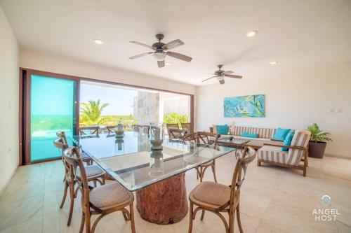uma grande sala de estar com mesa e cadeiras em Beachfront Villas with Private Pool Steps to the Sea! em Chicxulub