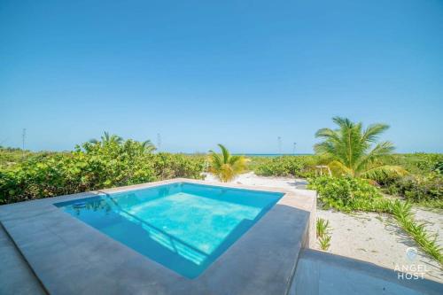 uma piscina em cima de uma casa com praia em Beachfront Villas with Private Pool Steps to the Sea! em Chicxulub