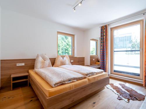 een slaapkamer met een bed en een groot raam bij Mamalisl in Mittersill