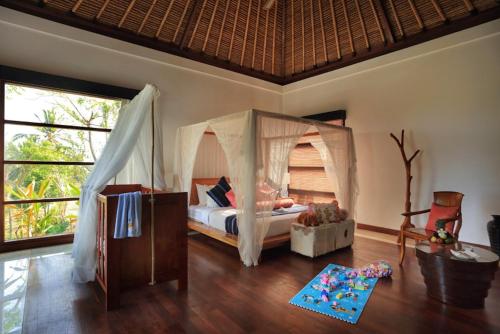 a bedroom with a bed with a canopy at Villa The Jiwa in Tanjung