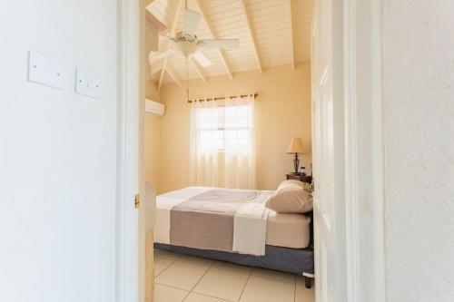 a bedroom with a bed and a ceiling fan at Oceanview Terrace I Full Kitchen I Steps to Beach I WiFi in Saint Lucy