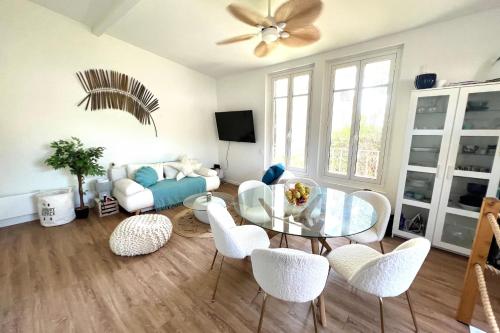 een woonkamer met een glazen tafel en witte stoelen bij House Facing the sea - Golfe Juan - 4 people in Vallauris