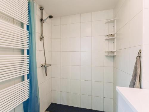 y baño con ducha de azulejos blancos. en Noordikhoeve, en Reutum