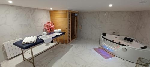 une salle de bain avec une baignoire et un lavabo et une baignoire dans l'établissement Magnifique loft jacuzzi et sauna Lanester-Lorient, à Lanester