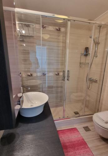 a bathroom with a shower with a tub and a toilet at Place 2 Be in Nafpaktos
