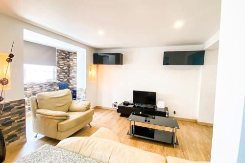 a living room with a couch and a tv at HU2i - In&Out Carcavelos in Carcavelos