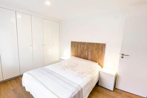 een witte slaapkamer met een bed en witte kasten bij HU2i - In&Out Carcavelos in Carcavelos