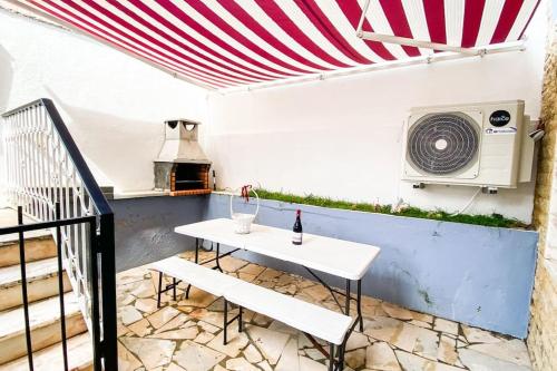 een patio met een witte tafel en een magnetron bij HU2i - In&Out Carcavelos in Carcavelos